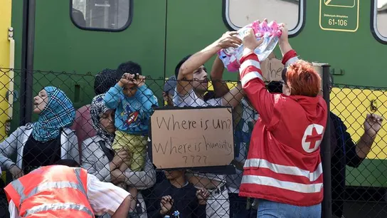 Miembros de la Cruz Roja reparten botellas de agua a los refugiados Miembros de la Cruz Roja reparten botellas de agua a los refugiados