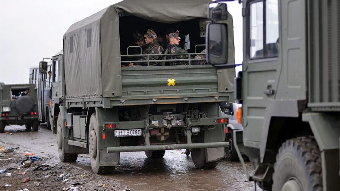 Veh&iacute;culos militares en un campo improvisado para refugiados cerca de Roszke