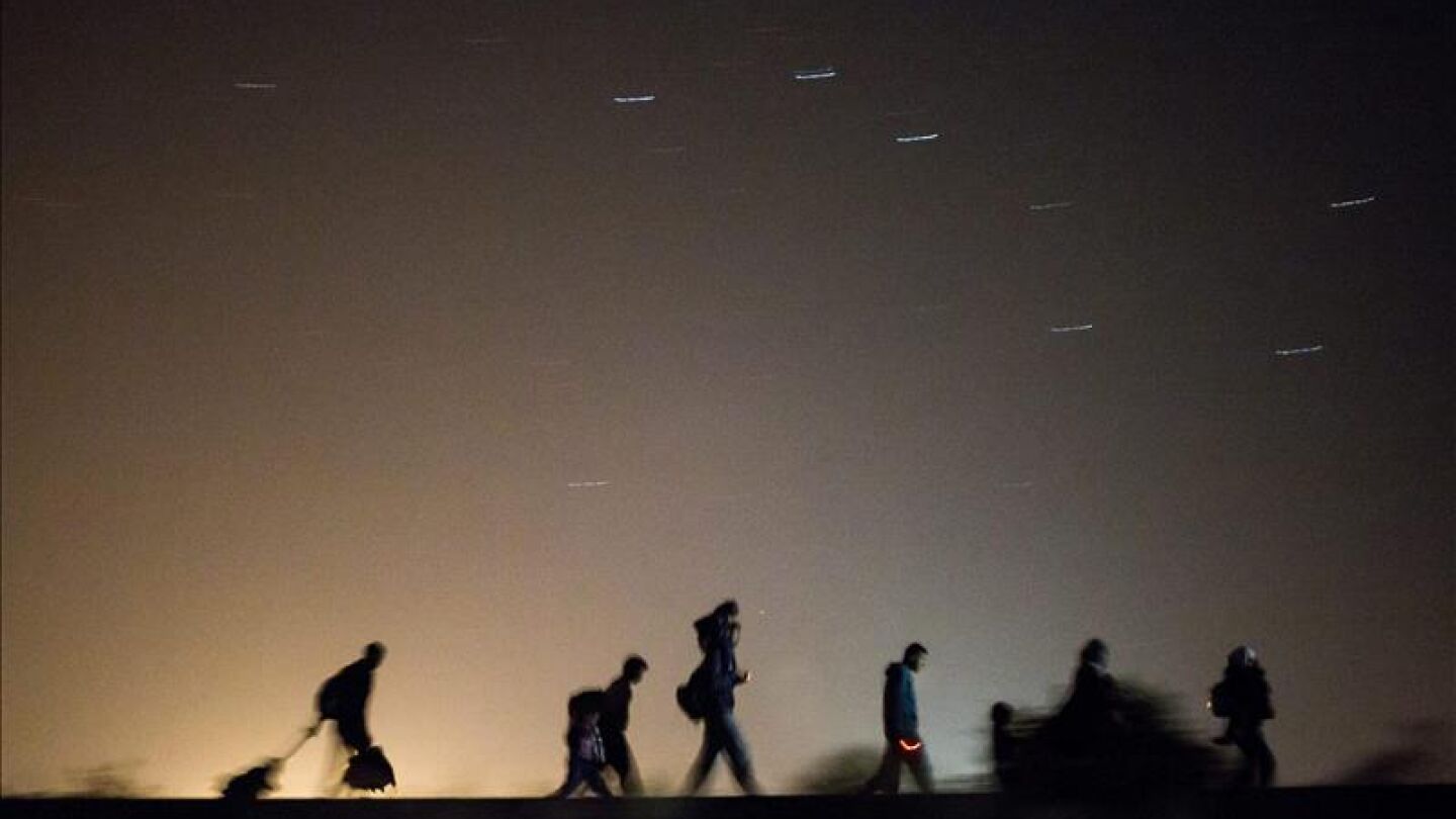 Refugiados caminan por las v&iacute;as del tren de Horgos a Szeged cerca de Rozke en Hungr&iacute;a