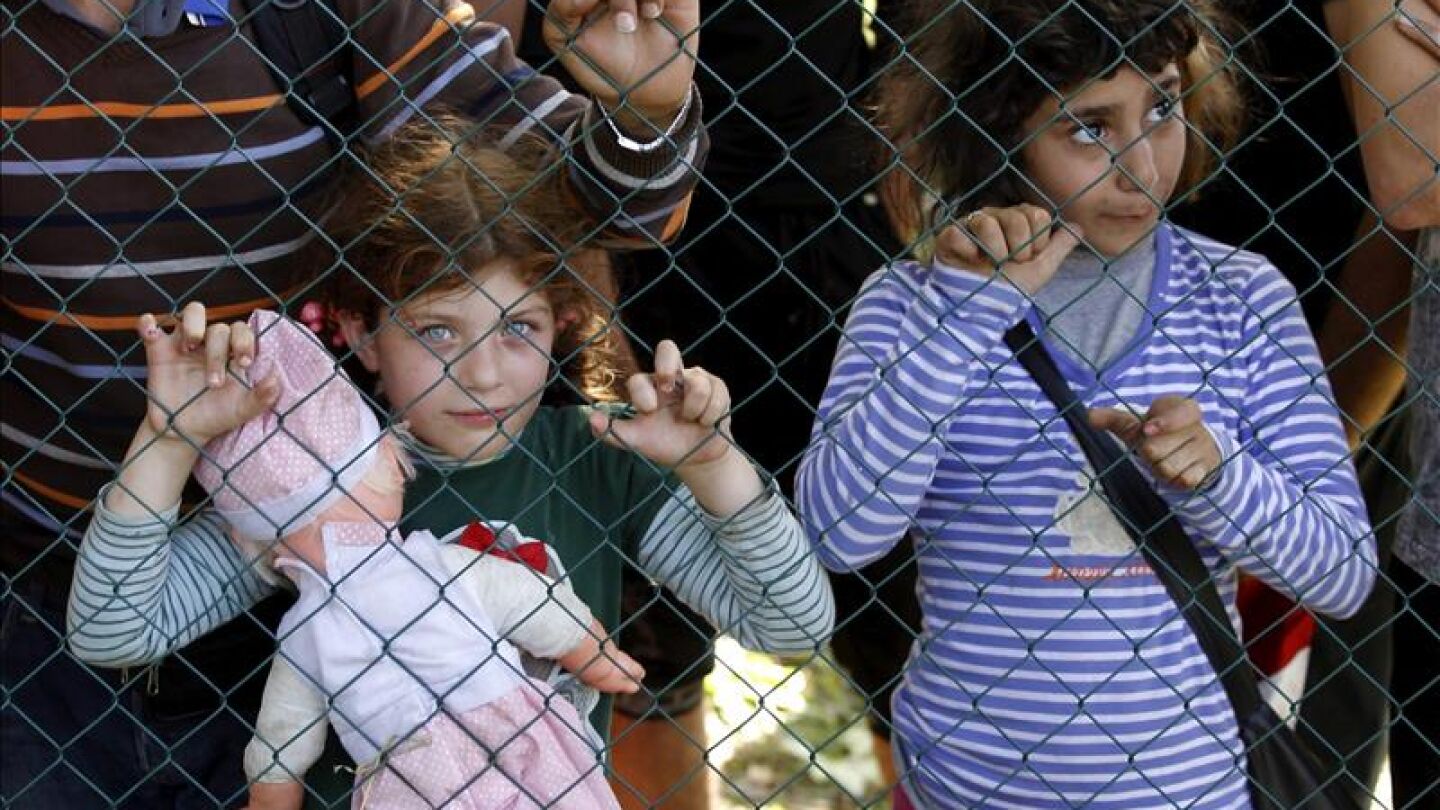 Dos ni&ntilde;os refugiados esperan este jueves para registrarse tras haber cruzado la frontera entre Serbia y Croacia