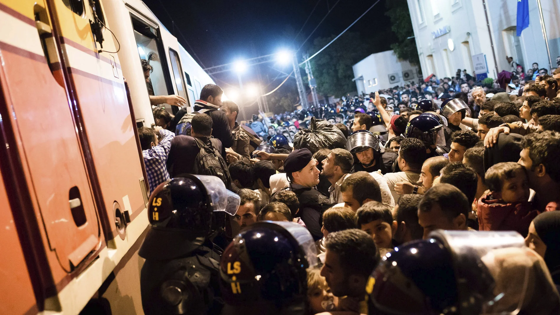 Refugiados intentan subir a bordo de un tren en la frontera entre Serbia y Croacia