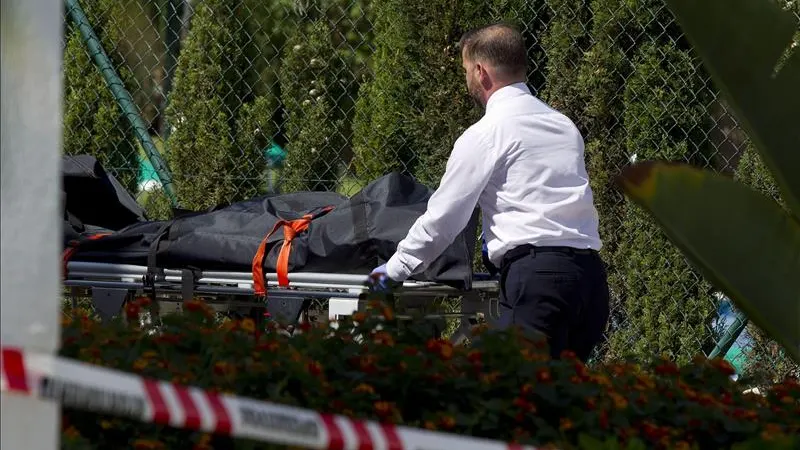 Operarios de la funeraria trasladan el cuerpo de un hombre de 30 años que ha muerto hoy al recibir varios disparos en Mijas