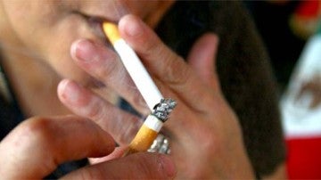 Una persona encendiéndose un cigarro