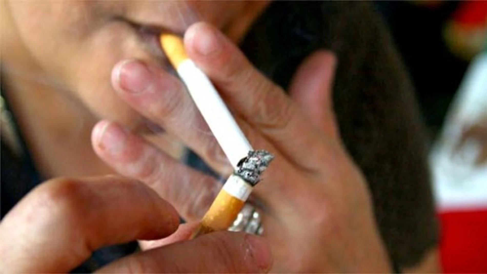 Una persona encendiéndose un cigarro