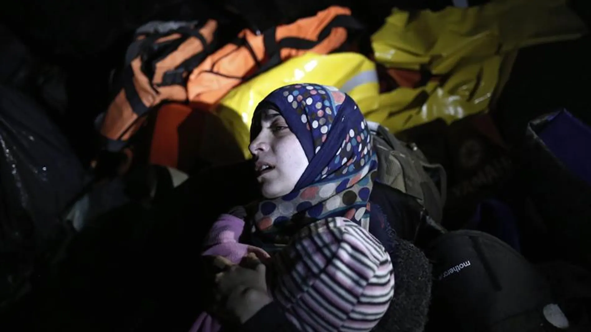 Una mujer siria sostiene a su bebé en Lesbos