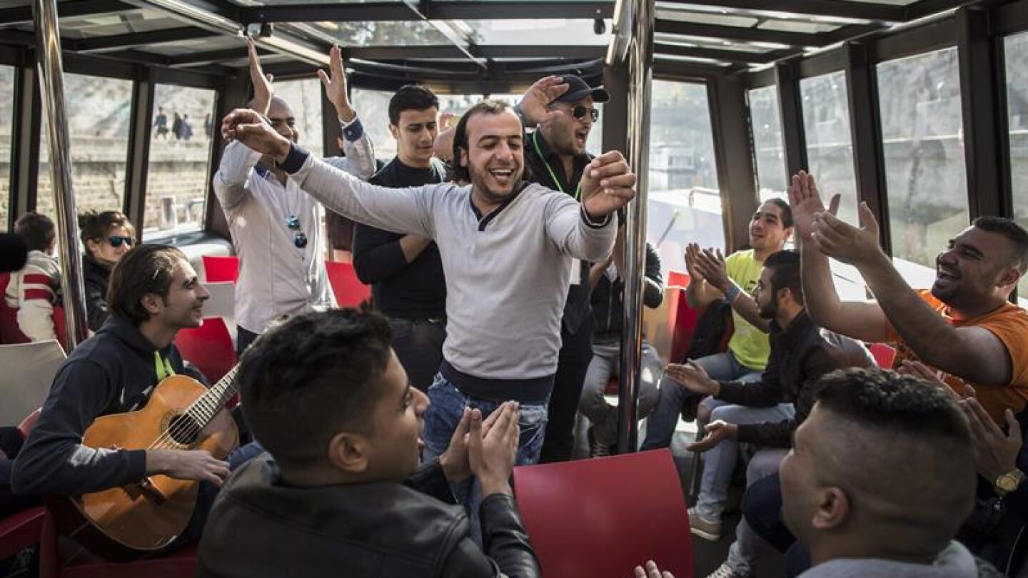Refugiados sirios e iraqu&iacute;es cantan en el r&iacute;o Sena