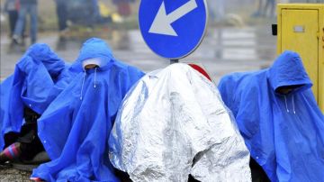 Refugiados esperan bajo la lluvia en la frontera entre Croacia y Eslovenia 