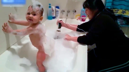 Una mujer introduce una batidora en el baño de su bebé para crear espuma Una mujer introduce una batidora en el baño de su bebé para crear espuma