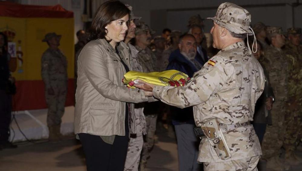 La vicepresidenta del Gobierno, Soraya Sáenz de Santamaría, recibe la bandera de manos del jefe del contingente español