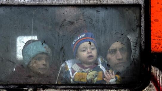 Un familia de refugiados mira a trav&eacute;s de la ventana del tren