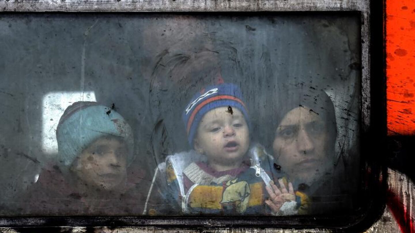 Un familia de refugiados mira a trav&eacute;s de la ventana del tren