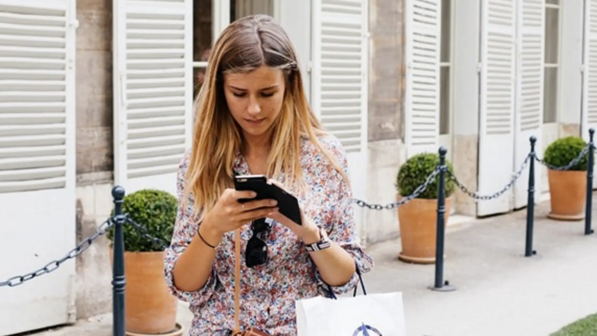 Una usuaria consulta su teléfono móvil