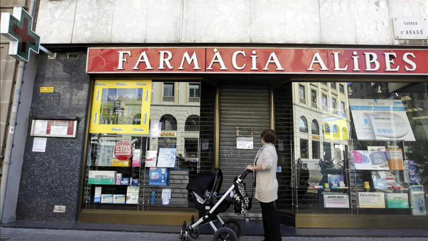 Una mujer contempla la fachada de una farmacia cerrada en el centro de Barcelona. Una mujer contempla la fachada de una farmacia cerrada en el centro de Barcelona.