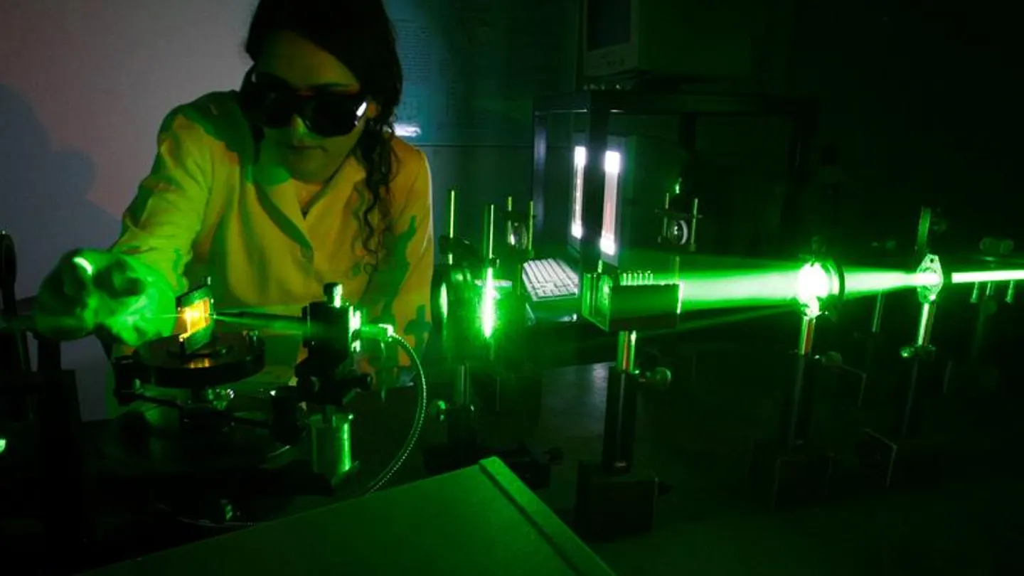 Miembro del equipo de investigación probando el láser Miembro del equipo de investigación probando el láser