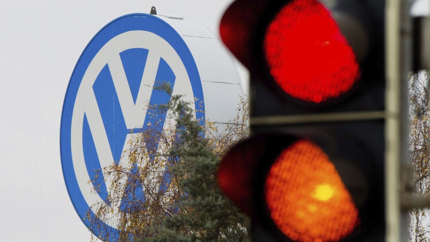 Logotipo de Volkswagen junto a un sem&aacute;foro en rojo y naranja en Fallersleben, Alemania.