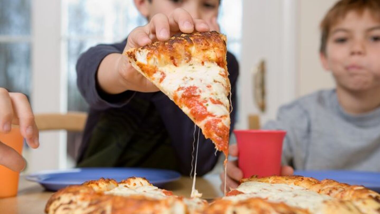 Ni&ntilde;os comiendo pizza