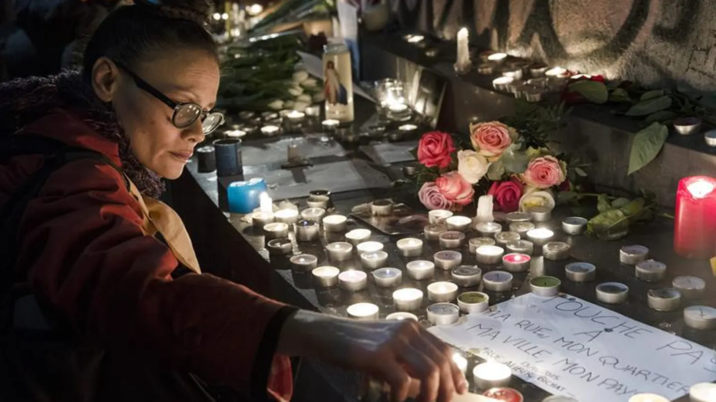Una mujer enciende velas en la plaza de la República en París Una mujer enciende velas en la plaza de la República en París