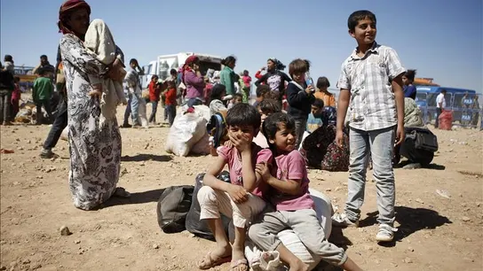 Niños refugiados junto a adultos (Archivo) Niños refugiados junto a adultos (Archivo)