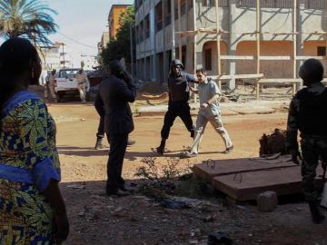 Un rehén es escoltado por personal militar de Mali a su salida del hotel Radisson Un rehén es escoltado por personal militar de Mali a su salida del hotel Radisson