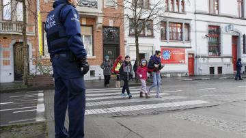 Un policía belga hace guardia a las puertas de un colegio en Bruselas