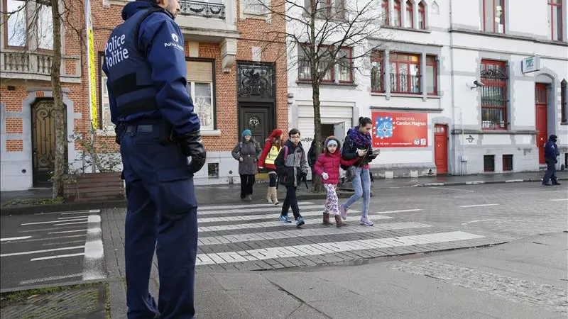 Un policía belga hace guardia a las puertas de un colegio en Bruselas