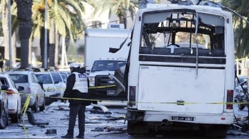 Policías forenses tunecinos inspeccionan los restos de un autobús tras un atentado en Túnez