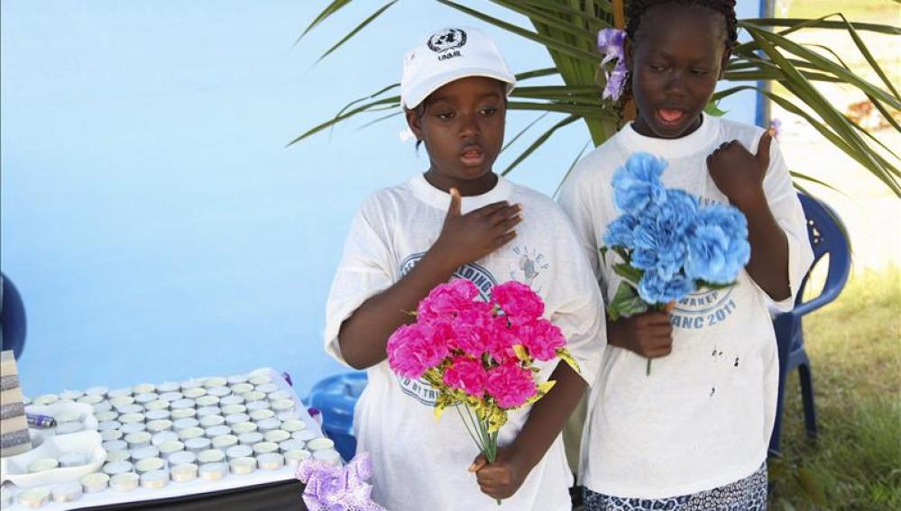 Niñas liberianas rezan con flores