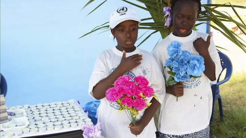 Niñas liberianas rezan con flores