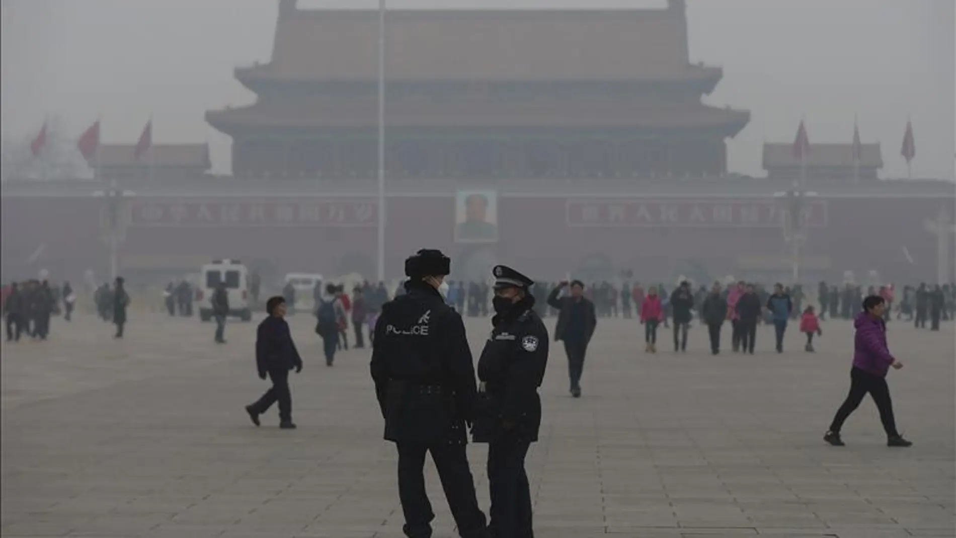 Dos policías usan mascarillas mientras hacen guardia en la plaza de Tiananmen en Pekín
