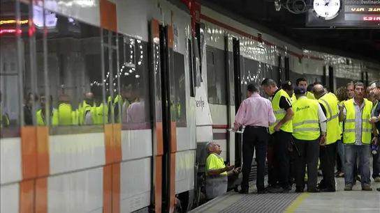 Trabajadores de Renfe revisan un tren en un andén Trabajadores de Renfe revisan un tren en un andén