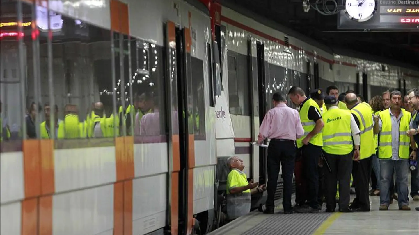 Trabajadores de Renfe revisan un tren en un andén Trabajadores de Renfe revisan un tren en un andén