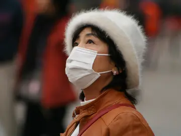 Una mujer se tapa por la contaminación Una mujer se tapa por la contaminación