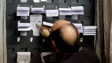  Un hombre elige las papeletas para las elecciones generales