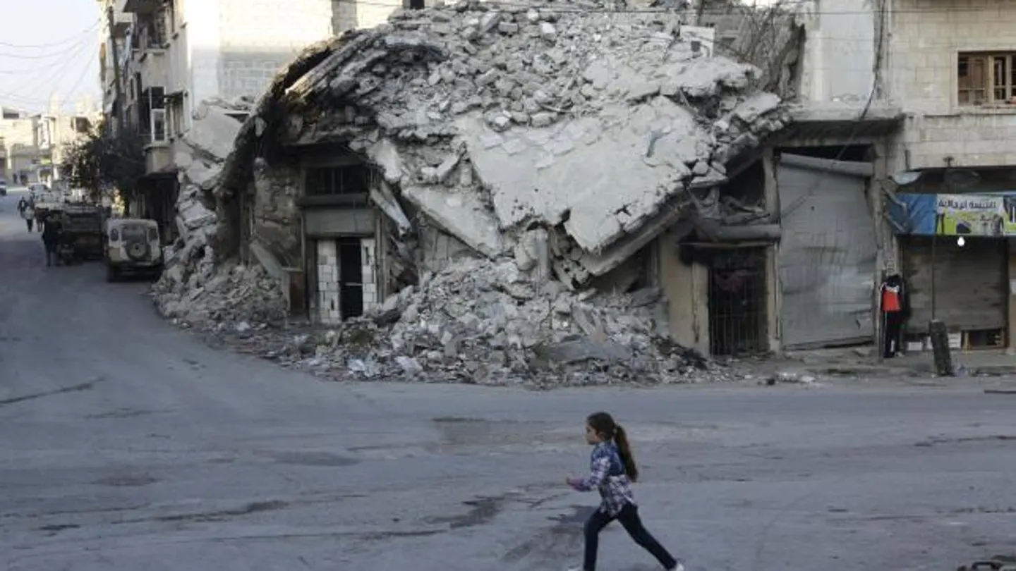 Una chica pasa por los edificios dañados de una zona controlada por los rebeldes de Maarat an-Numan Una chica pasa por los edificios dañados de una zona controlada por los rebeldes de Maarat an-Numan