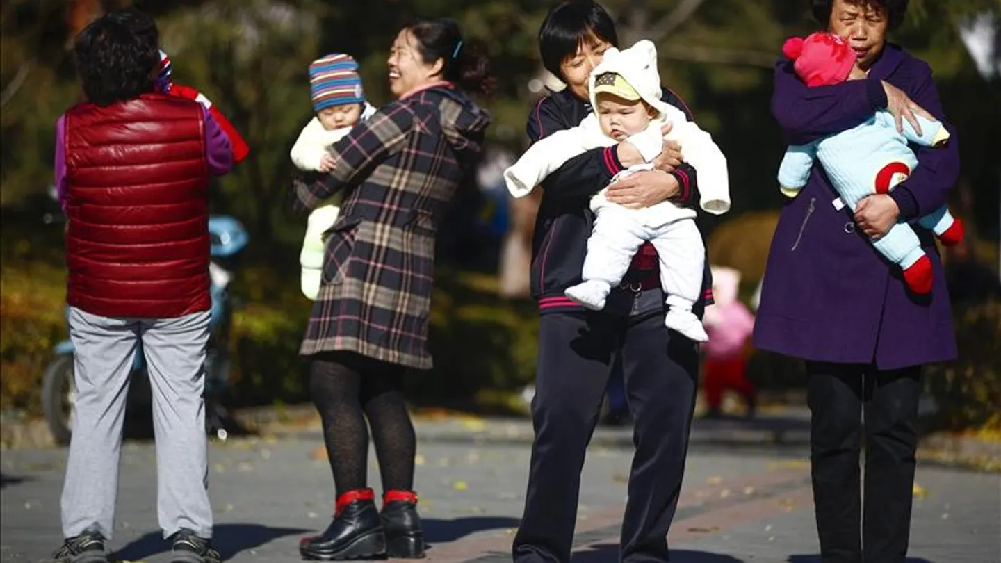 Varias mujeres sujetan en brazos a bebés en un parque de Pekín, China Varias mujeres sujetan en brazos a bebés en un parque de Pekín, China