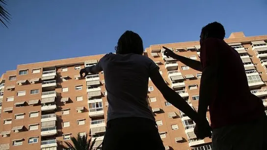 Dos personas mirando un bloque de edificios Dos personas mirando un bloque de edificios