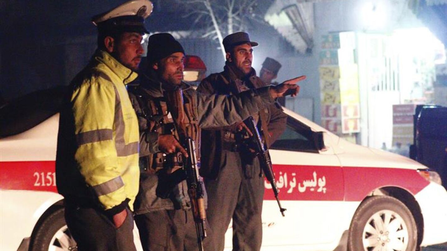 Miembros de los servicios de seguridad afganos permanecen en guardia en el lugar donde se ha producido un ataque talib&aacute;n en Kabul