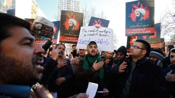 Manifestantes iraníes sostienen carteles del clérigo chií opositor Nimr Baqir al Nimr durante una protesta cerca a la embajada saudí en Teherán