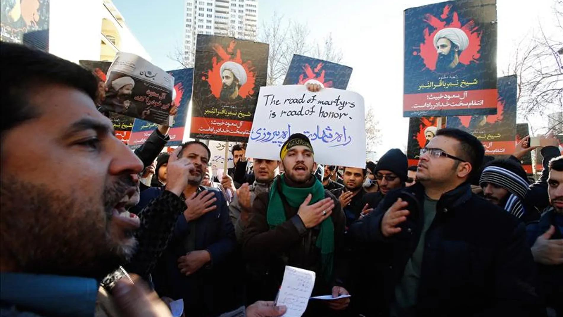 Manifestantes iraníes sostienen carteles del clérigo chií opositor Nimr Baqir al Nimr durante una protesta cerca a la embajada saudí en Teherán