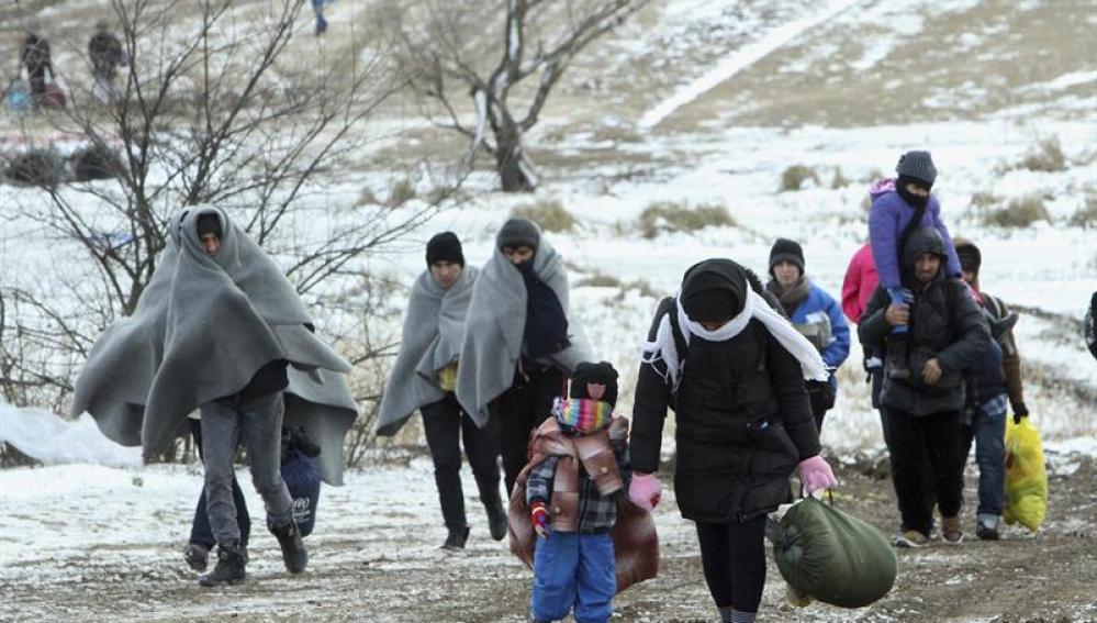 Refugiados de Siria, Irak y Afganistán caminan hacia un campamento temporal en Serbia