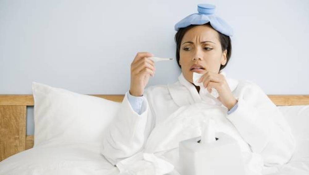 Una mujer con la gripe en la cama