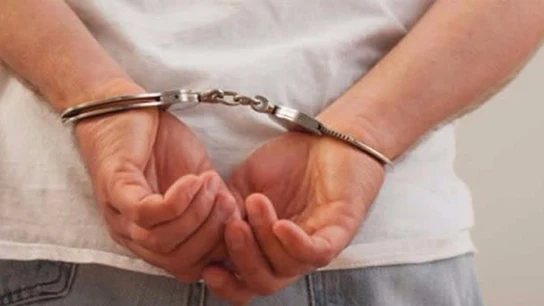 Un hombre detenido y esposado Un hombre detenido y esposado