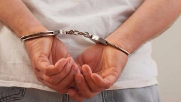 Un hombre detenido y esposado Un hombre detenido y esposado