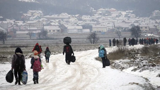Un grupo de refugiados avanzando por un camino nevado Un grupo de refugiados avanzando por un camino nevado