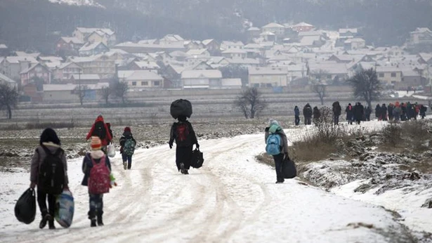 Un grupo de refugiados avanzando por un camino nevado Un grupo de refugiados avanzando por un camino nevado