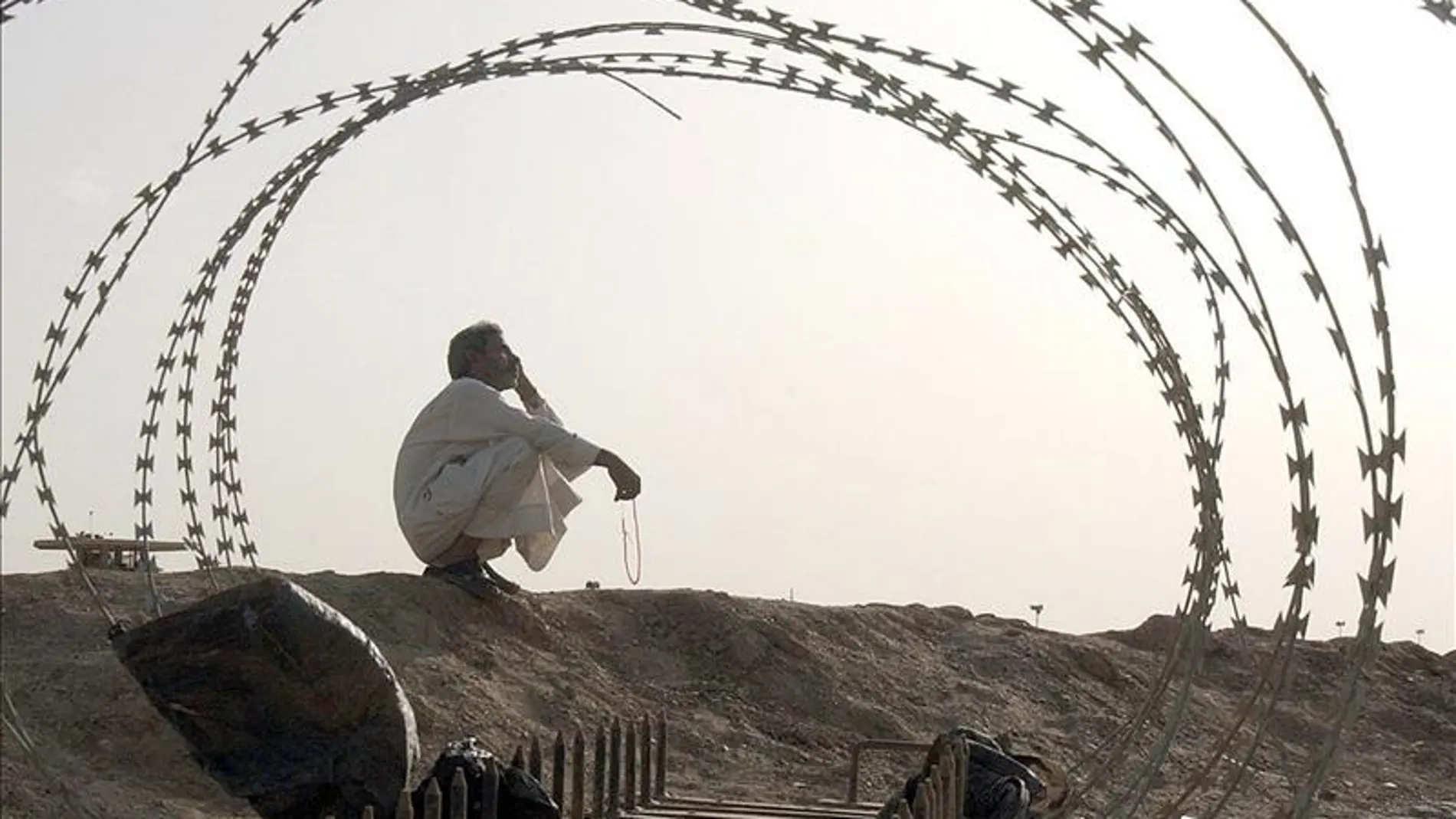 Un iraquí sentado al frente de la prisión de Abu Ghraib al oeste de Bagdad, Irak