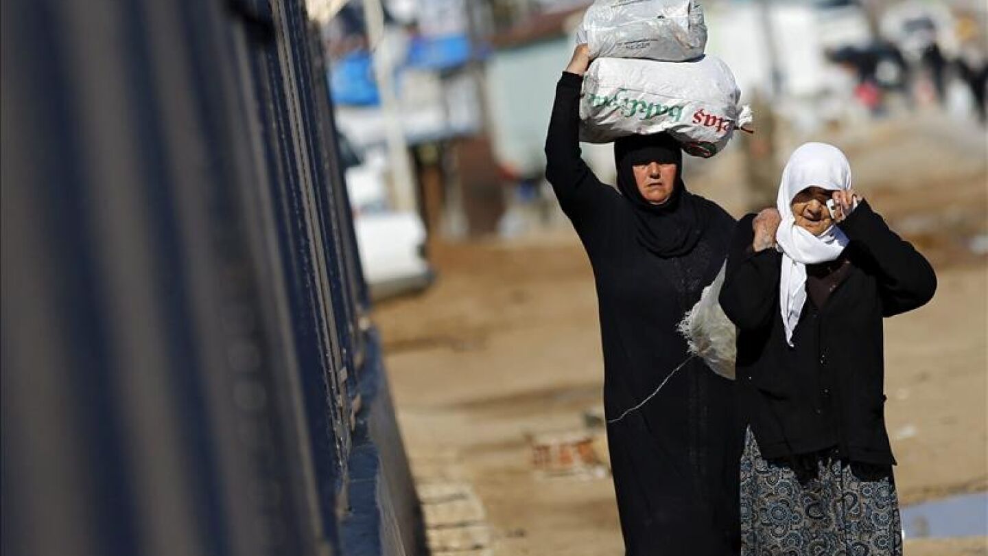 Refugiados sirios trasladan bolsas de alimentos en el paso fronterizo de &Ouml;nc&uuml;pinar, en Kilis, 