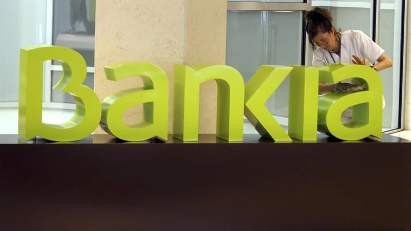 Una operaria limpia el logo de Bankia