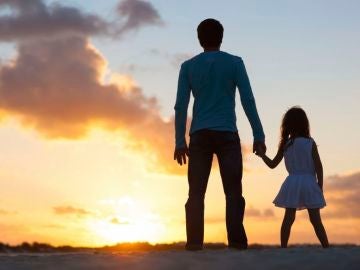 Un padre con su hija durante la puesta de sol Un padre con su hija durante la puesta de sol