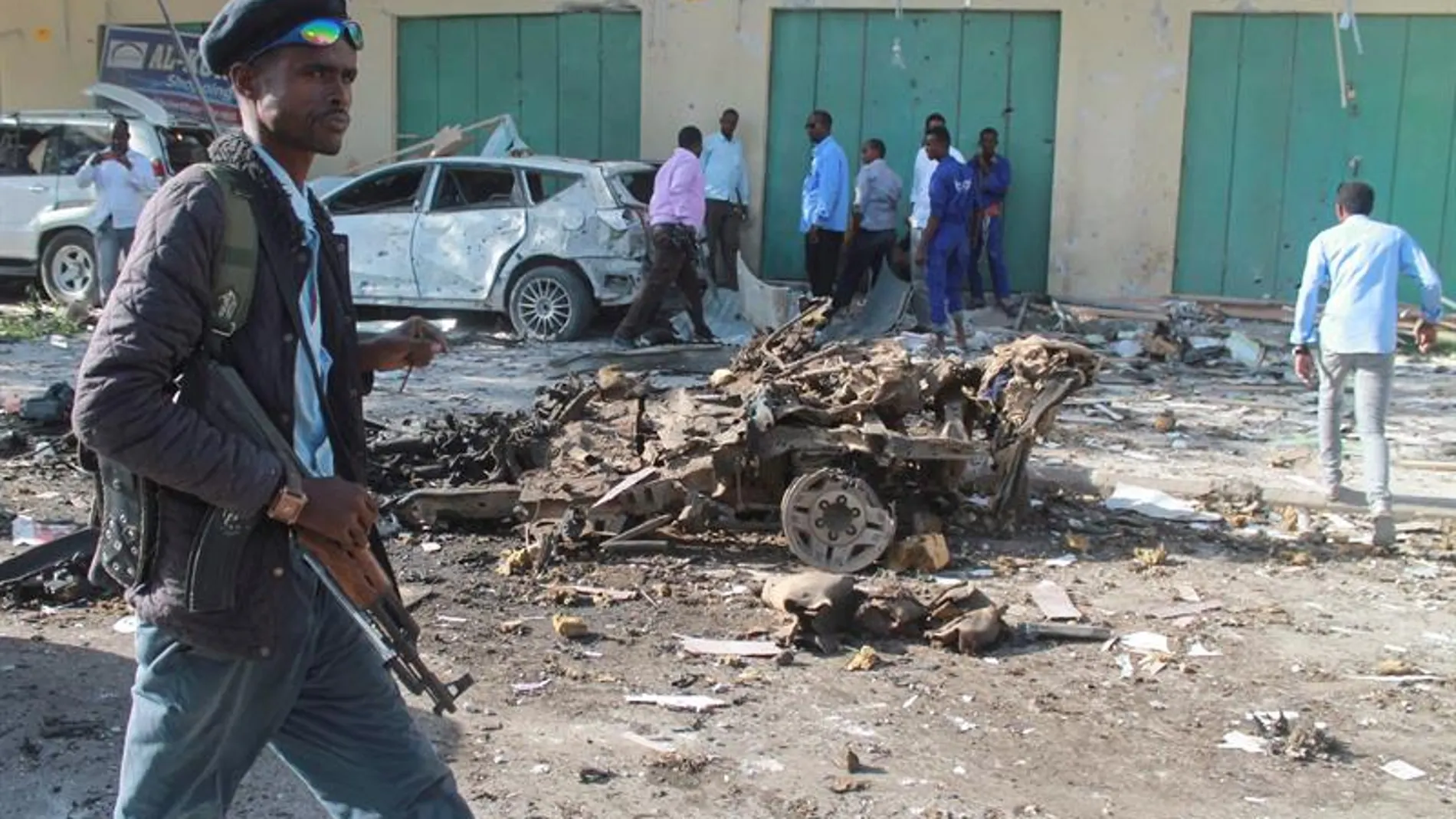 Un oficial de seguridad somalí pasa delante de los restos de un vehículo tras una explosión en Mogadiscio